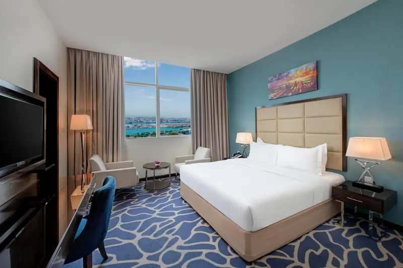 Chambre d'hôtel lumineuse avec un grand lit et une vue sur la mer.