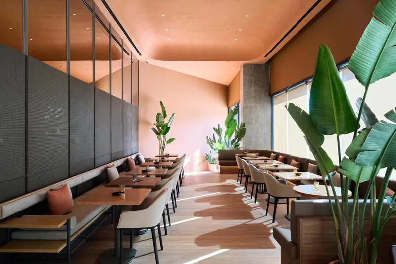 Une salle de restaurant lumineuse avec des tables et des banquettes.