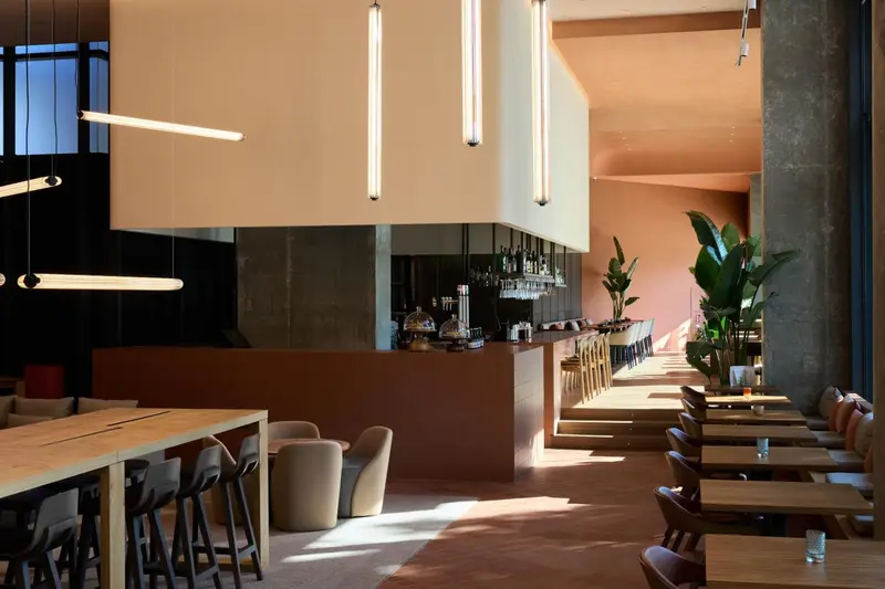 Un espace lumineux avec un comptoir de bar et des tables.
