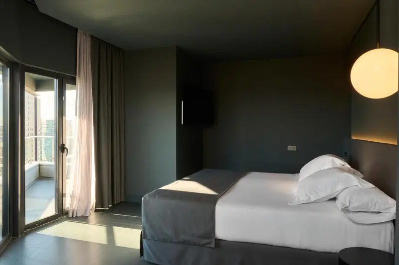 Une chambre moderne avec un grand lit et un accès à un balcon.
