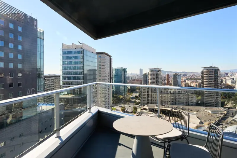 Terrasse avec mobilier d'extérieur donnant sur une vue urbaine.