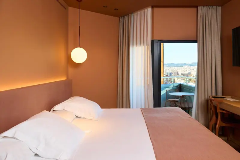 Une chambre à coucher lumineuse avec un grand lit et une vue sur la ville.