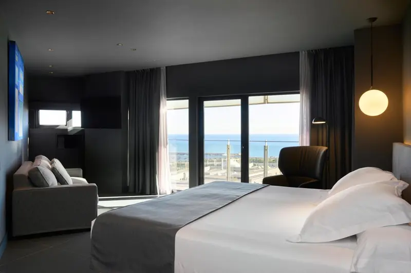 Une chambre moderne avec un grand lit et une vue sur la mer.