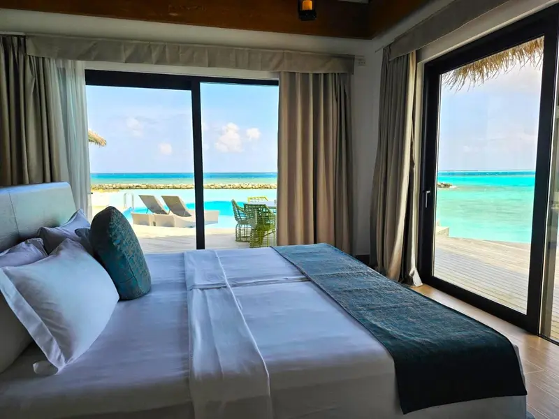Une chambre avec un grand lit donnant sur une vue sur l'océan.