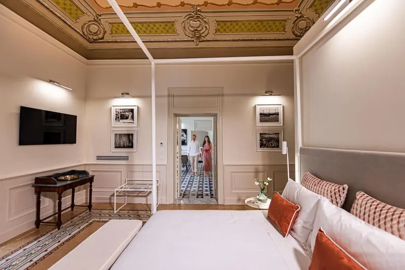 Une chambre à coucher lumineuse avec un grand lit et une décoration soignée.