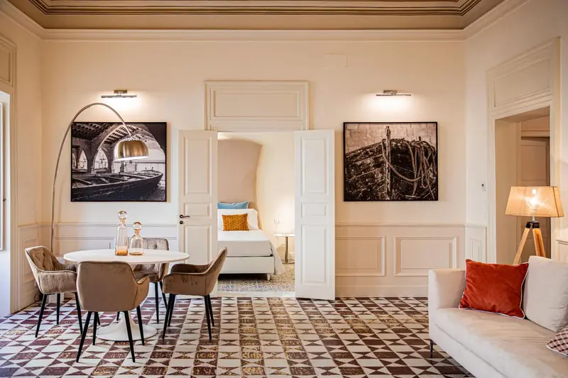 Espace de vie lumineux avec canapé, table et œuvres d'art murales.