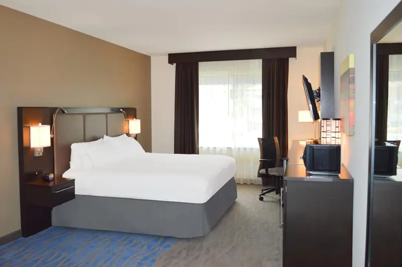 Une chambre d'hôtel lumineuse avec un grand lit et un espace de travail.