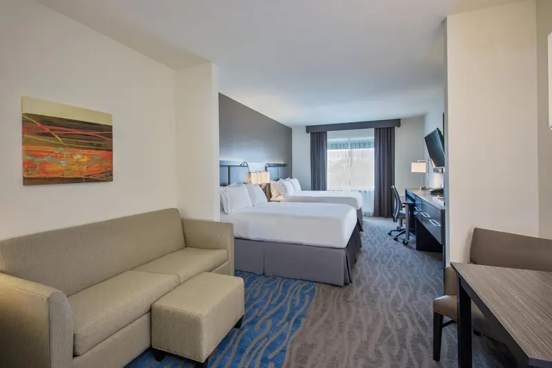 Une chambre d'hôtel lumineuse avec un canapé et un bureau.