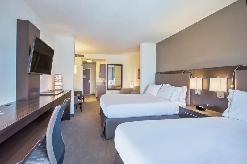 Une chambre d'hôtel moderne avec deux lits et un bureau.
