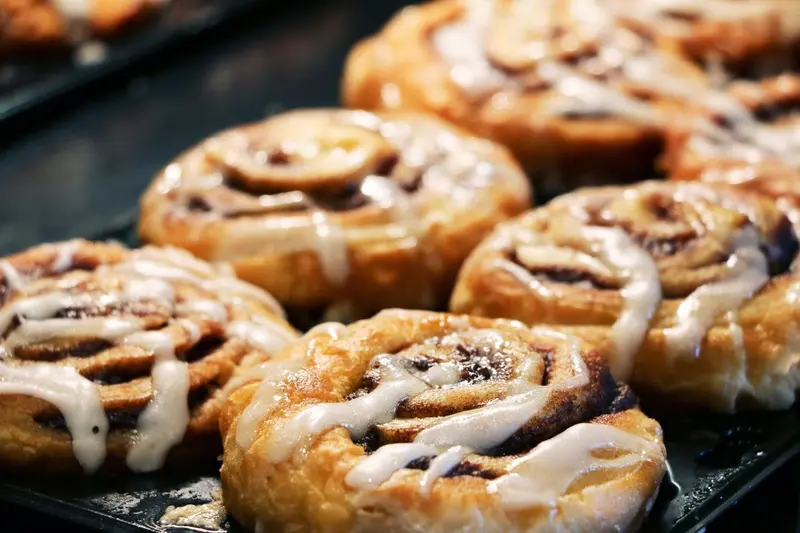 Des viennoiseries au caramel et au glaçage sont présentées sur une plaque.