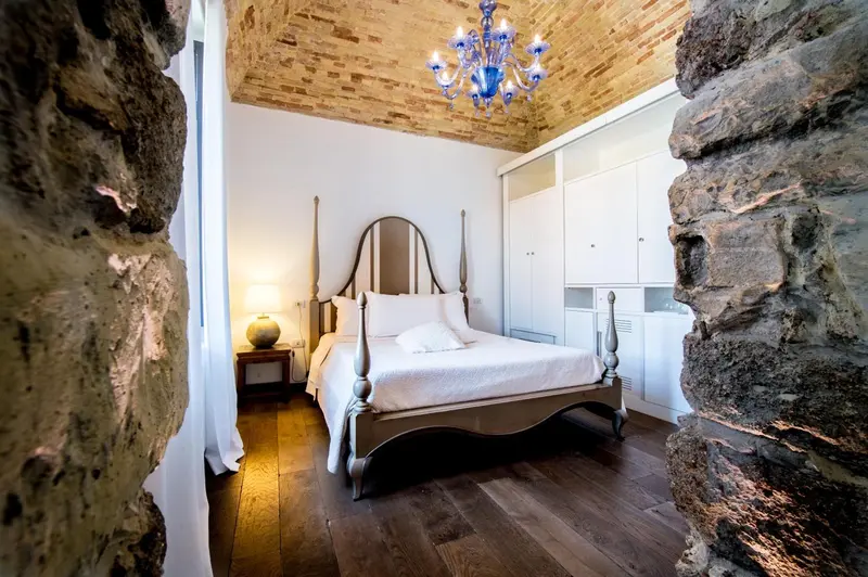 Une chambre à coucher avec un lit à baldaquin et des murs en pierre.
