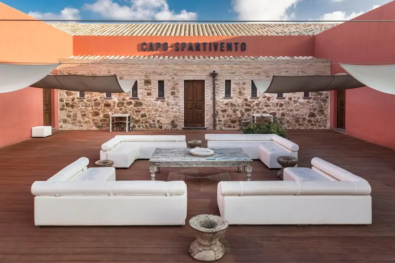 Terrasse aménagée avec des canapés blancs et une table basse.
