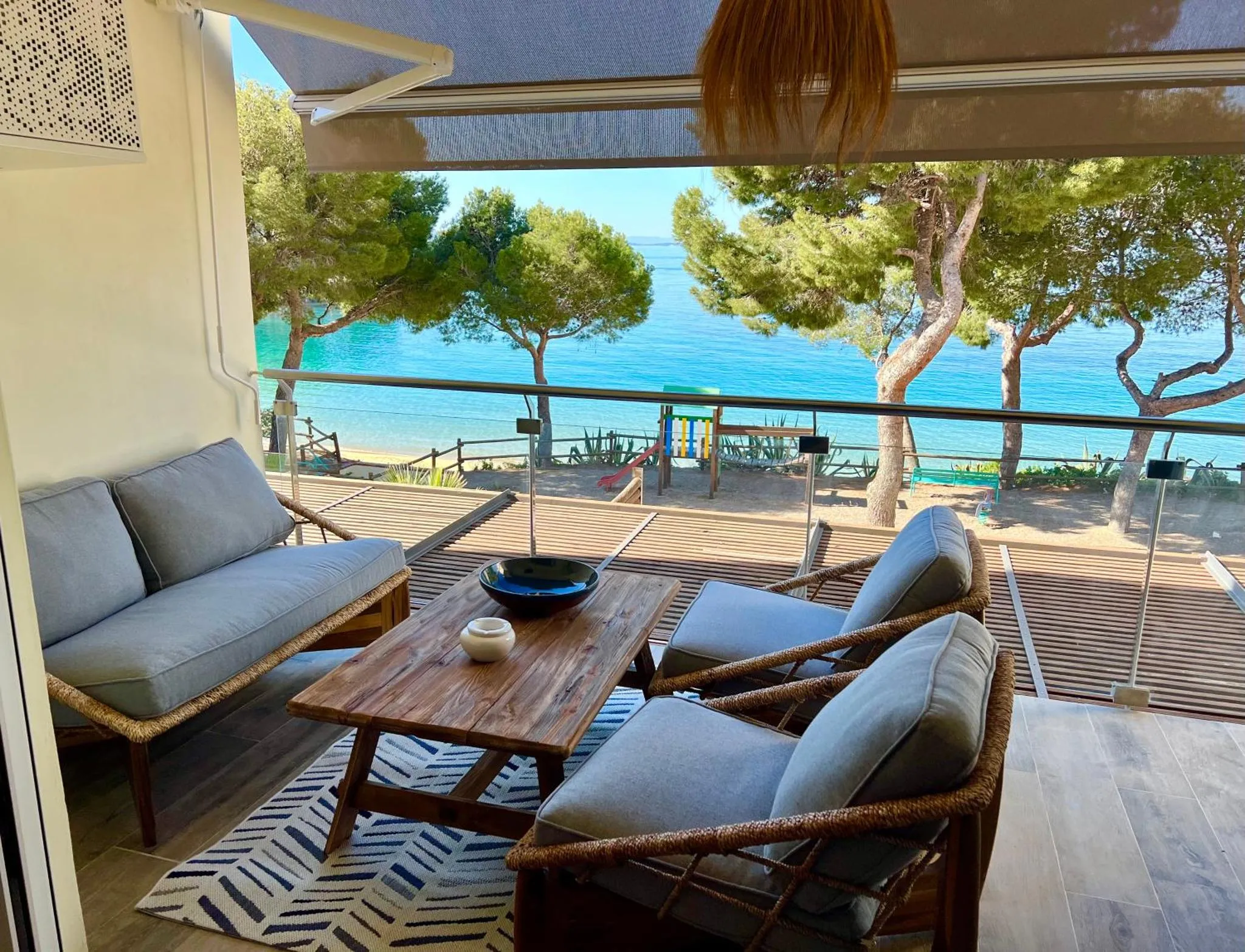 Un espace de détente extérieur avec canapés et table basse offre une vue sur la mer.