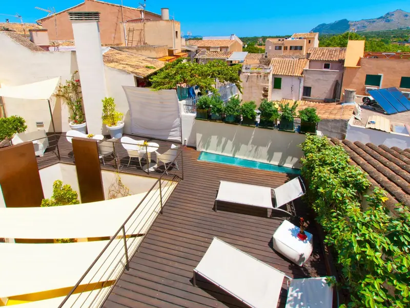 Terrasse aménagée avec transats et petite piscine en contrebas.