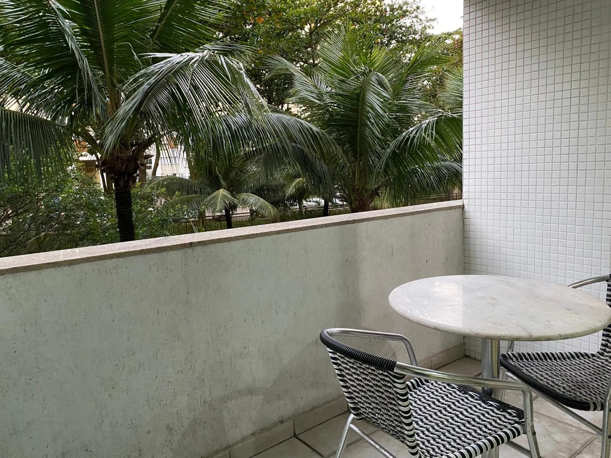Une terrasse avec une table et des chaises offre une vue sur la végétation luxuriante.