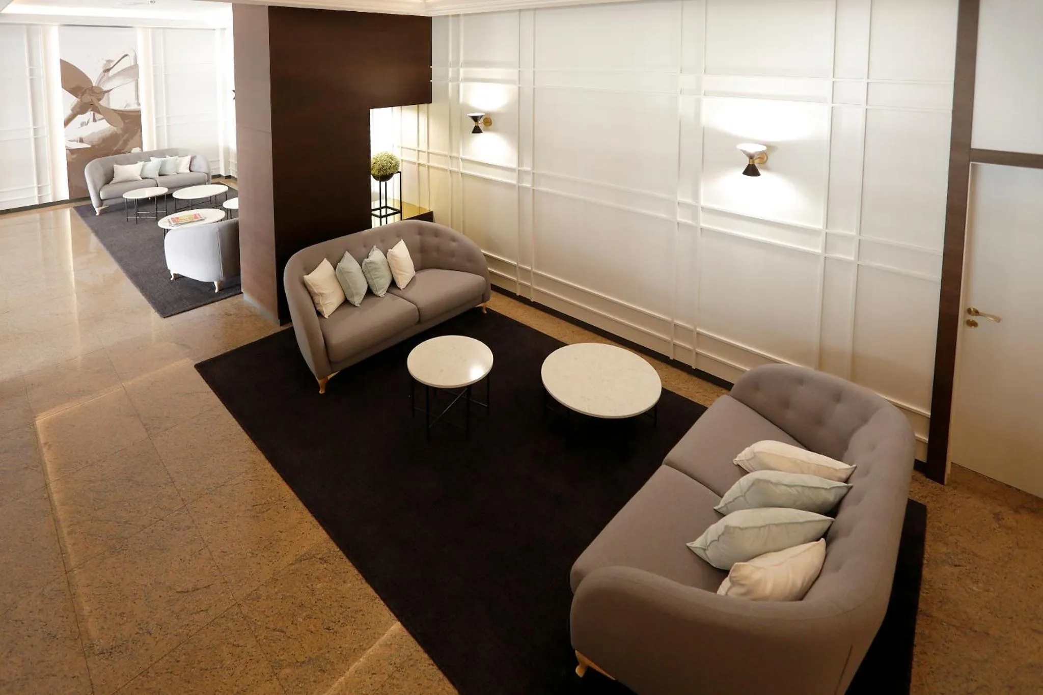 Espace de détente avec canapés et tables basses dans un intérieur moderne.