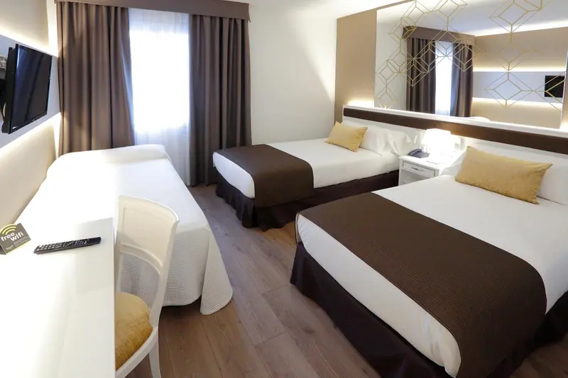 Chambre avec deux lits simples et un lit double, décoration moderne.