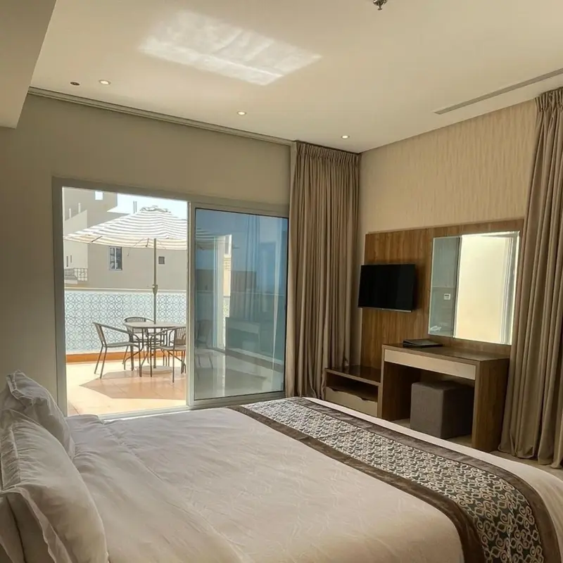 Une chambre lumineuse avec un grand lit et un accès à une terrasse.