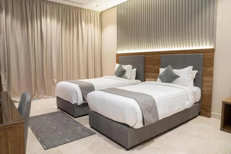 Une chambre avec deux lits simples et une décoration sobre.