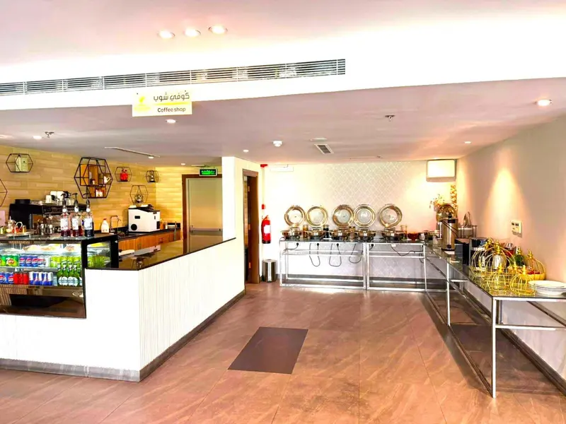 Un comptoir de buffet propose des pâtisseries et des boissons dans une salle lumineuse.