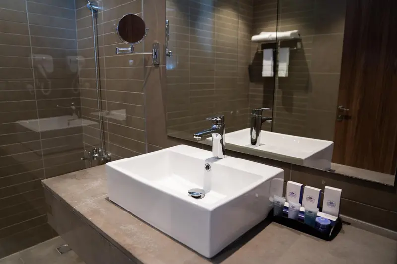 Un lavabo blanc et un robinet chromé dans une salle de bain moderne.