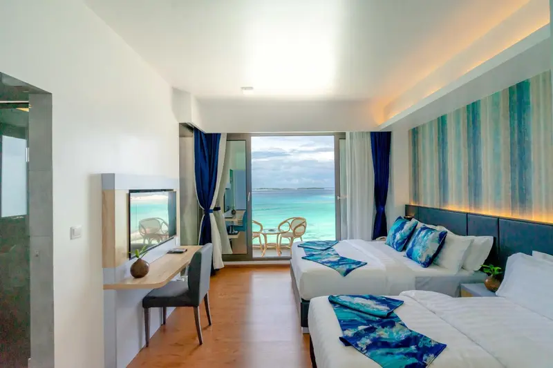 Chambre lumineuse avec vue sur l'océan et balcon.