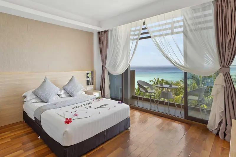 Une chambre lumineuse avec un grand lit et une vue sur la mer.