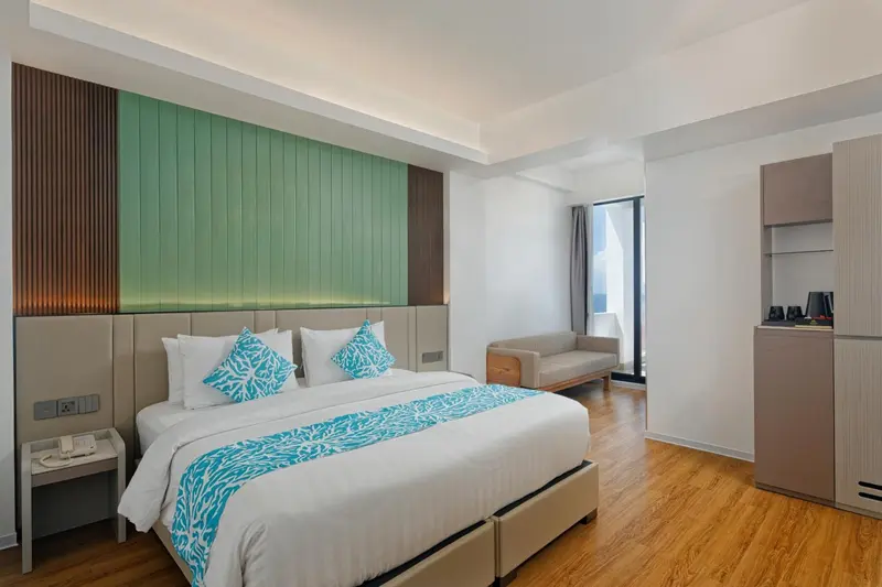 Une chambre lumineuse avec un grand lit et un canapé.