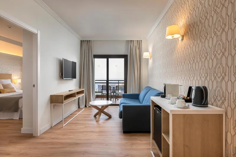 Un salon lumineux avec canapé et table basse, ouvert sur une terrasse.