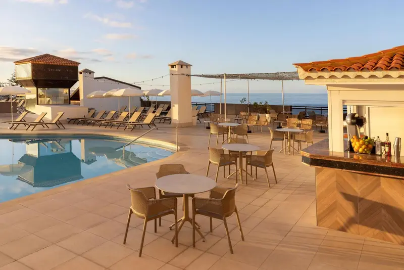 Terrasse avec piscine et bar en extérieur.
