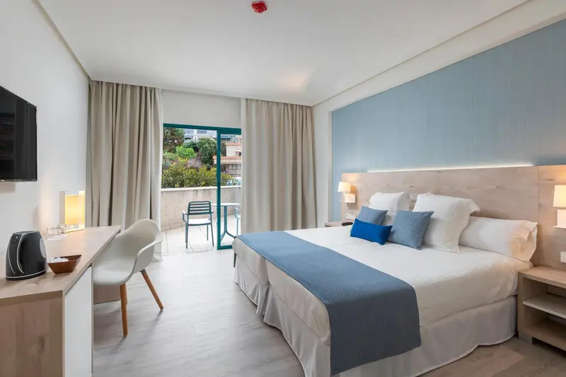 Une chambre lumineuse avec un grand lit et un balcon.