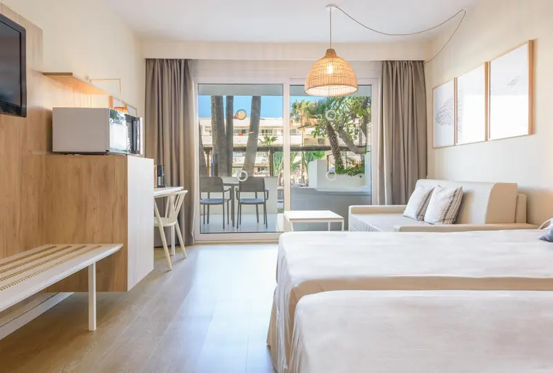 Une chambre lumineuse avec un canapé et un accès à une terrasse.