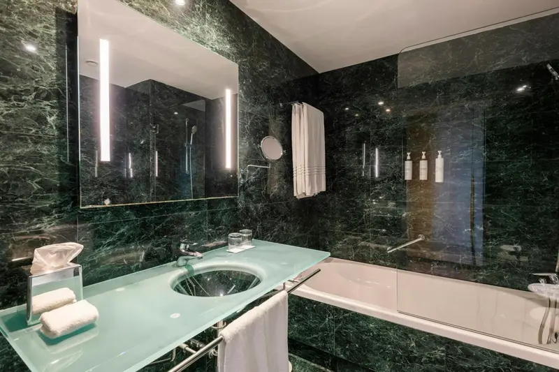 Une salle de bain moderne avec une baignoire et un grand miroir.