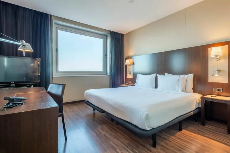 Une chambre d'hôtel moderne avec un lit double et un bureau.