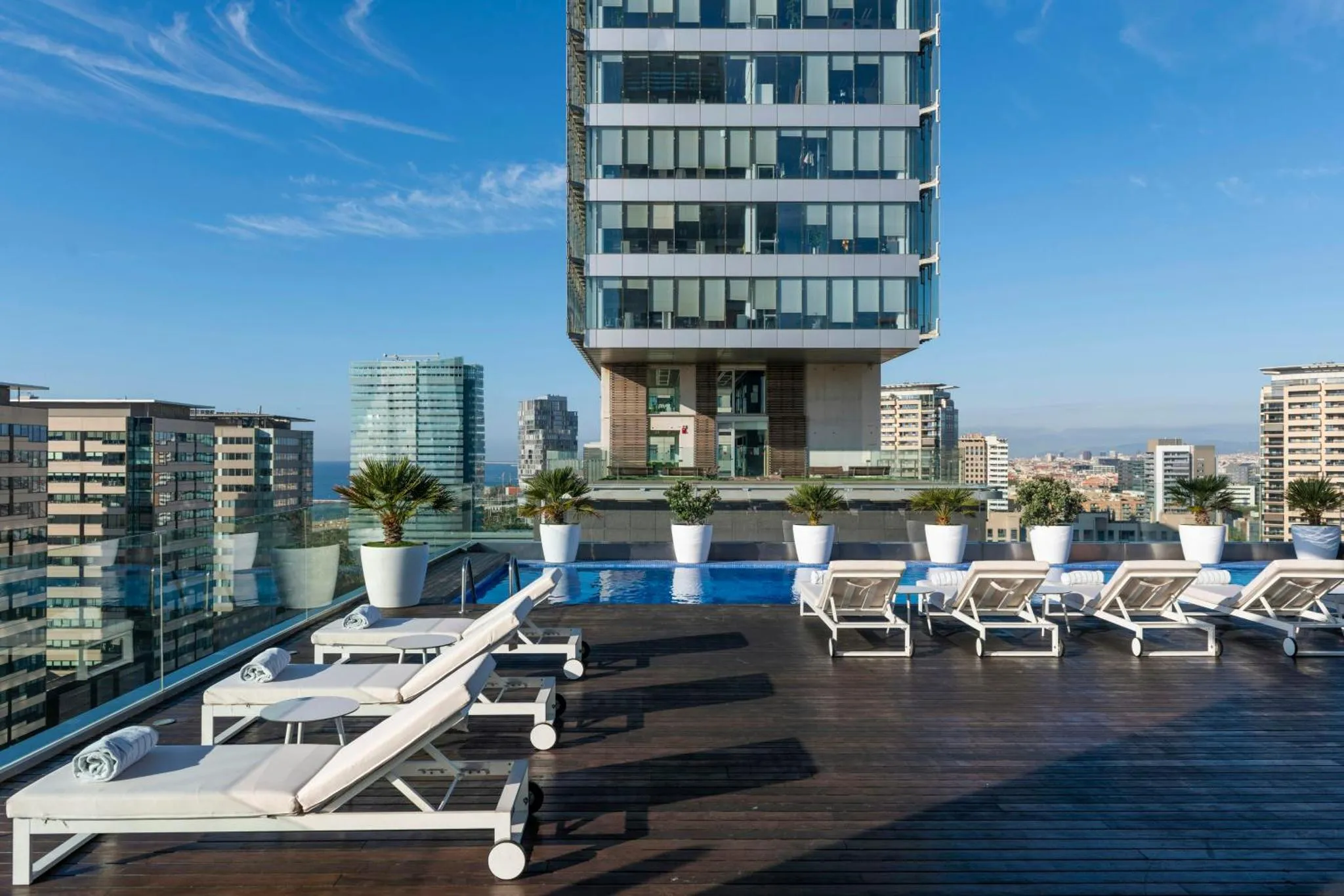 Terrasse avec piscine et transats ensoleillés.