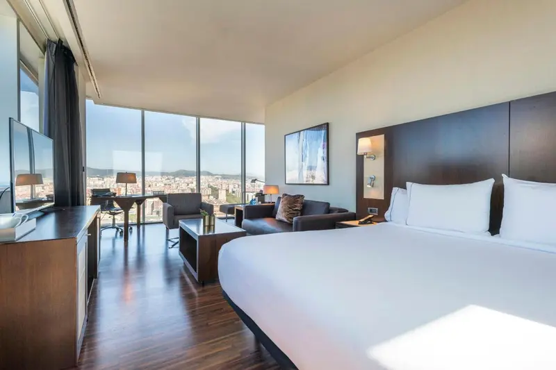 Chambre moderne avec un grand lit et une vue sur la ville.
