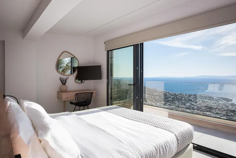 Une chambre lumineuse avec un grand lit et une vue sur la mer.