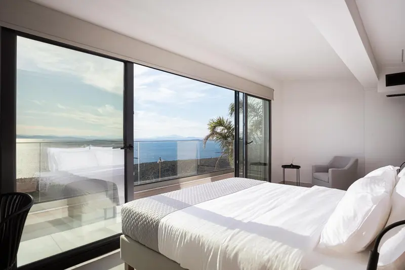 Une chambre lumineuse avec un grand lit et une vue sur la mer.