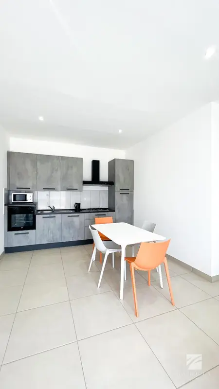 Une cuisine moderne avec une table et des chaises.