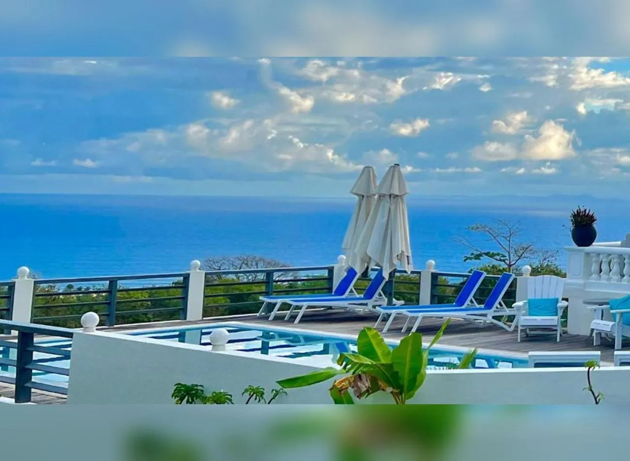 Terrasse avec transats et piscine face à la mer.