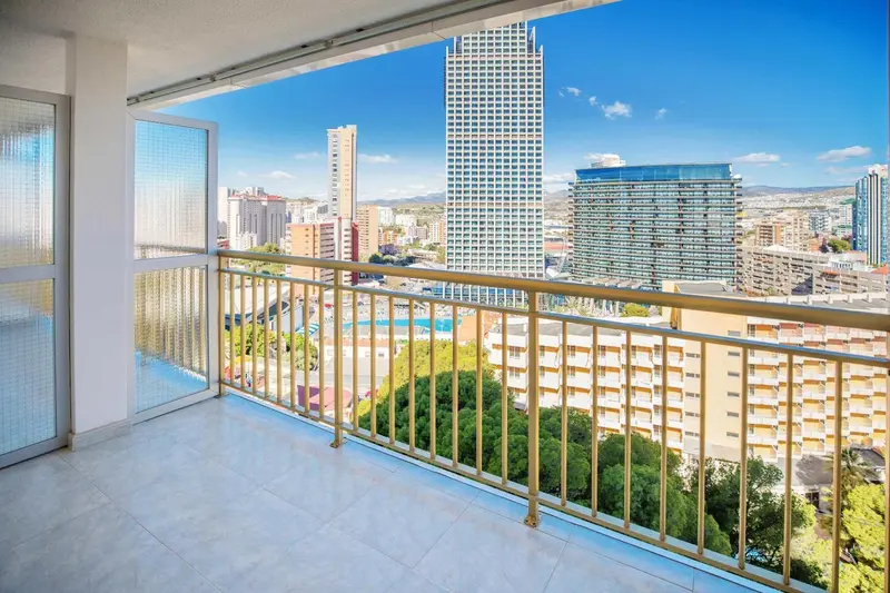 Vue sur la ville depuis un balcon avec garde-corps doré.