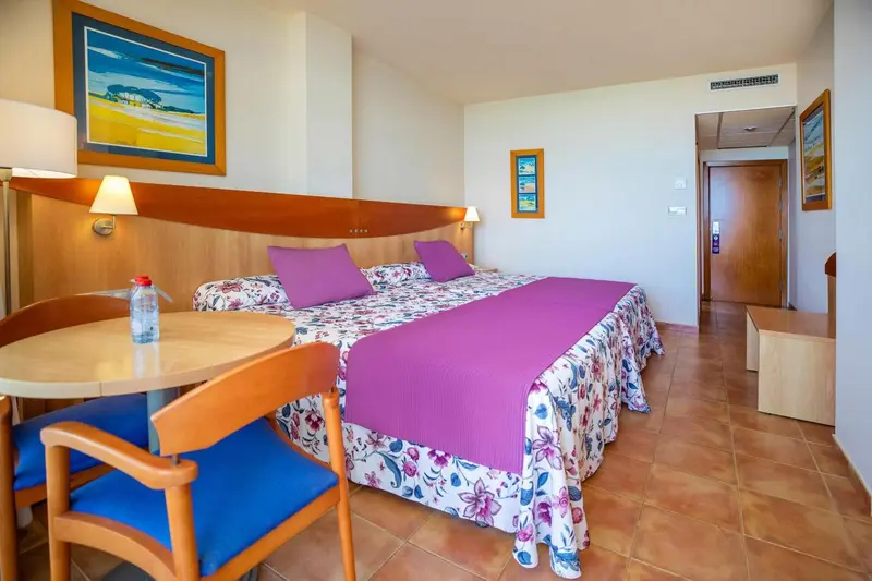 Une chambre lumineuse avec un lit double et une table basse.