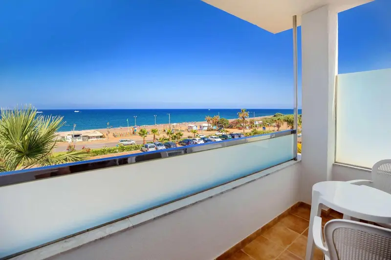 Vue sur la mer depuis un balcon avec mobilier d'extérieur.