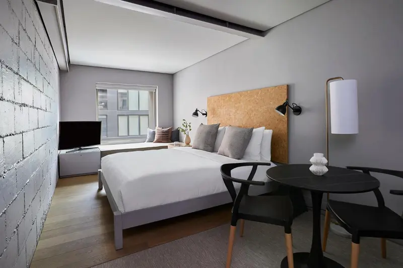 Une chambre moderne avec un grand lit et une petite table.