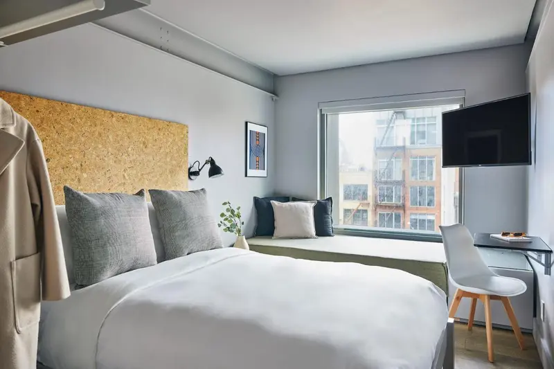 Une chambre lumineuse avec un lit confortable et un bureau.