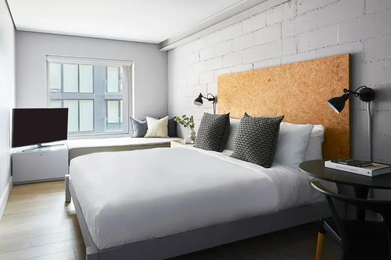 Une chambre lumineuse avec un grand lit et une décoration moderne.