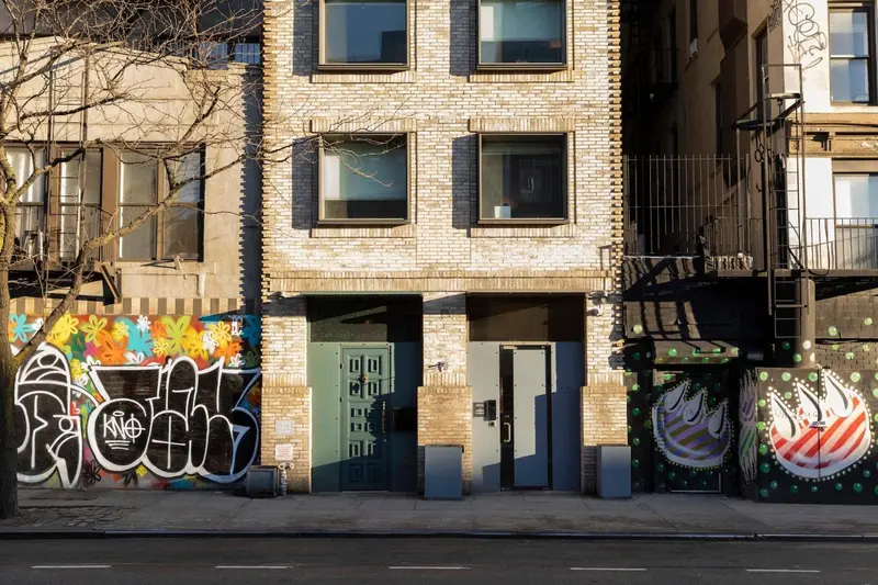 Façade d'un bâtiment urbain avec des graffitis et des portes grises.