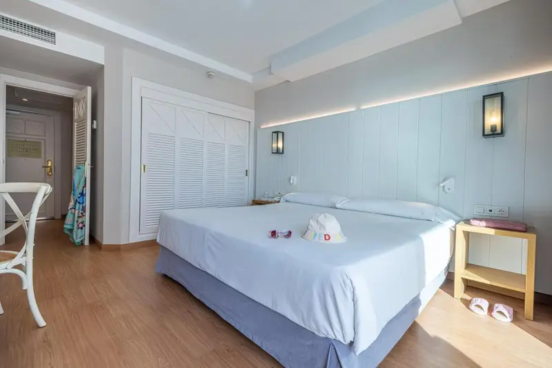 Une chambre lumineuse avec un grand lit et un espace de rangement.