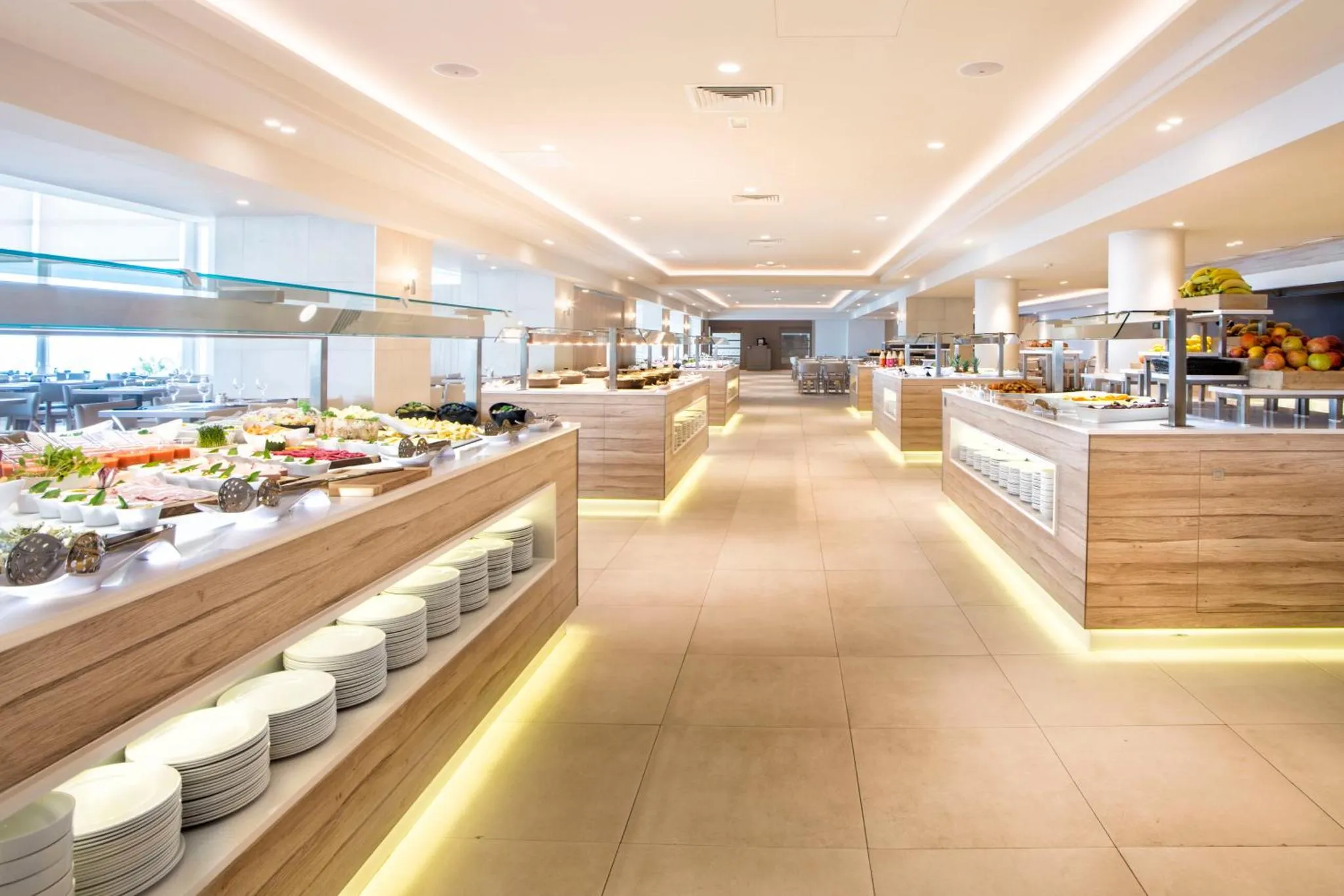 Une salle lumineuse présente un long buffet garni de divers plats.