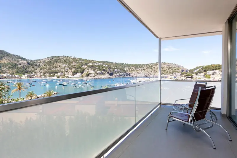 Terrasse moderne avec mobilier d'extérieur donnant sur une baie et des collines.